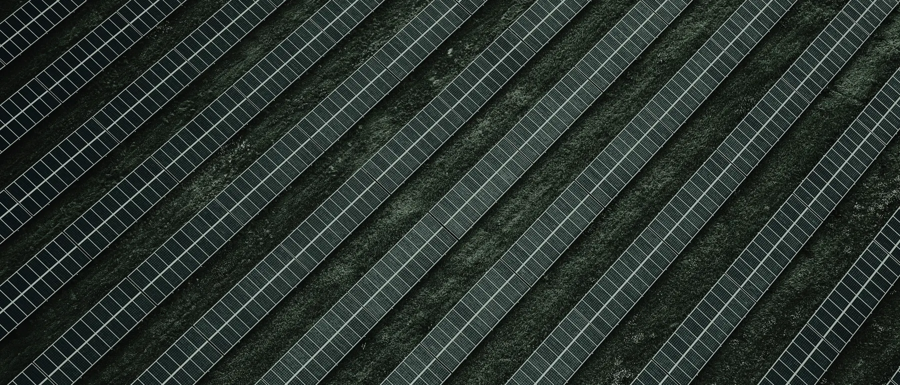 Aerial view of a utility-scale photovoltaic plant, rows of modules in geometric repetition
